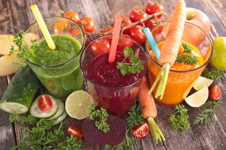 three colorful smoothies made out of fresh fruits and vegetables