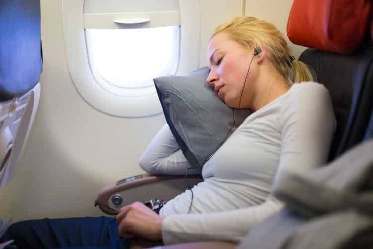 Woman sleeping fitfully on an airplane