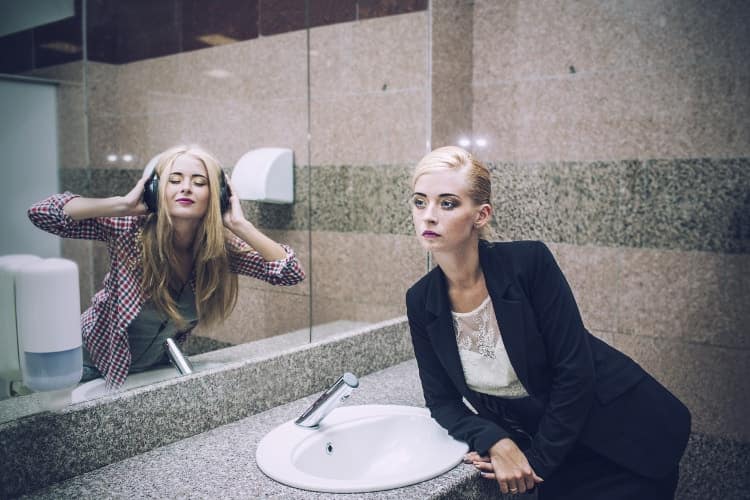 Woman in front of bathroom mirror with her alter ego in the reflection