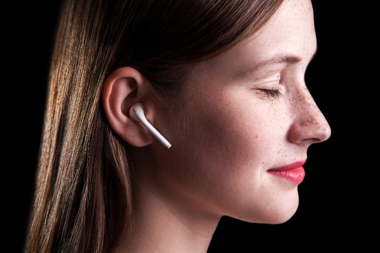 Woman listening to hypnosis audio through wireless earbuds