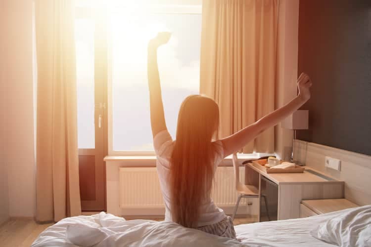 Young woman stretching in the morning as she greets the sunrise