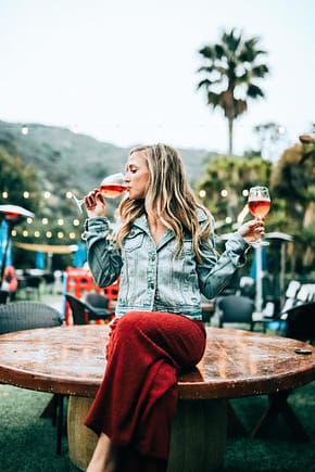 Young woman sipping from two glasses of rose wine