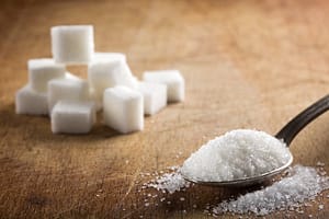 white granulated sugar and sugar cubes on a table