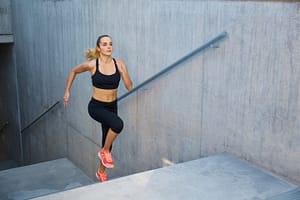 Athletic woman running up stairs during cardio - interval training