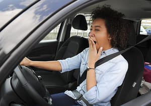 fatigued woman behind the wheel of a car