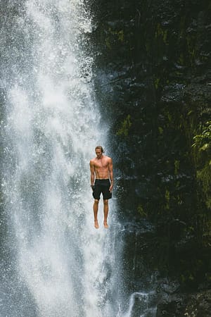 Man calmly jumping off of waterfall