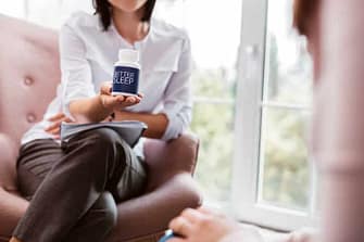 Woman holding out bottle of sleep supplement