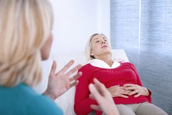 Woman undergoing hypnosis at therapist's office