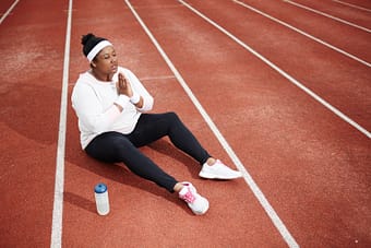 Woman giving gratitude on track before workout