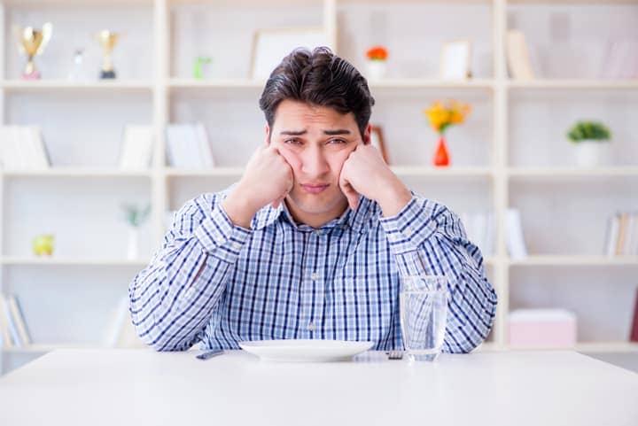 overweight man frustrated by eating diet foods