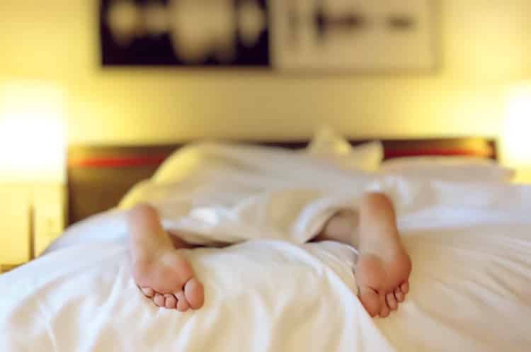 Person sleeping soundly with feet sticking out of bed