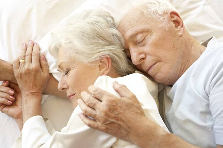 Older couple peacefully sleeping together in bed