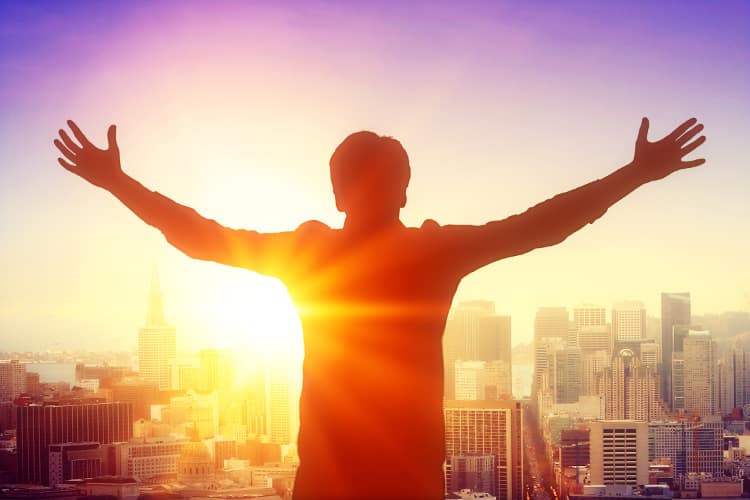 Man on skyscraper celebrating the sunrise