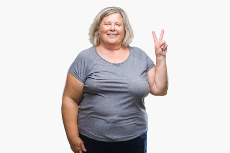 Overweight woman in grey T shirt giving the peace sign