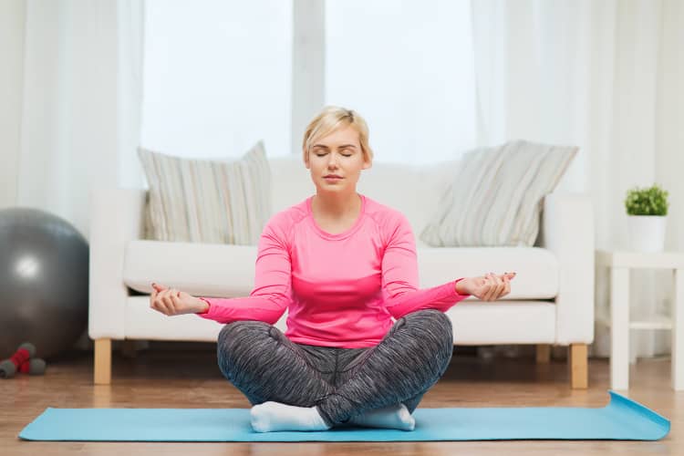 Woman meditating on yoga mat