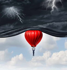 Optimistic red hot air balloon pushing away dark and stormy skies