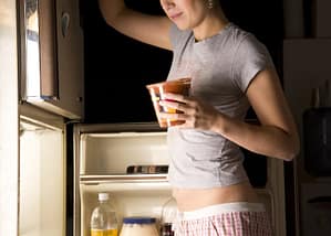 Woman opening refrigerator for midnight snack