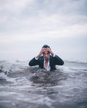 Man in suit emerging from ocean water