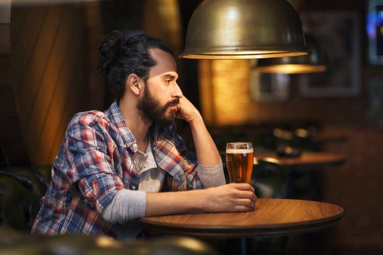 Man drinking beer in a bar all alone