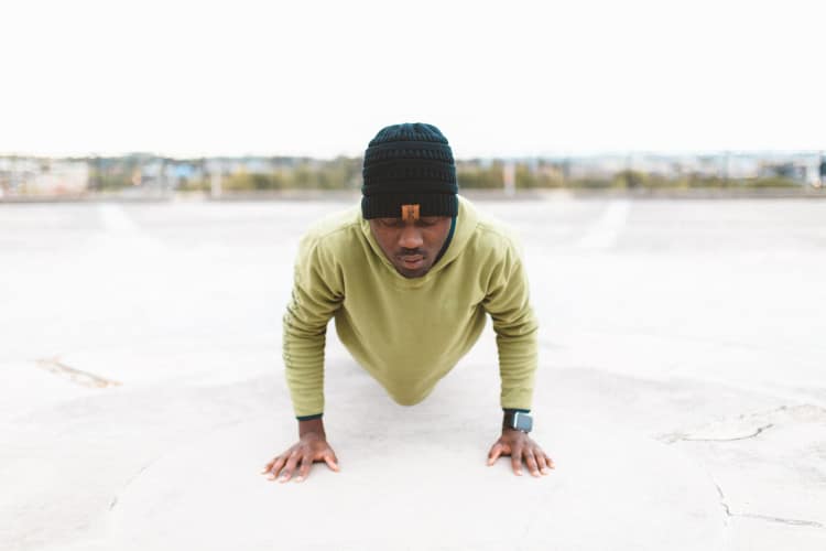 Fit man doing pushups on ball court